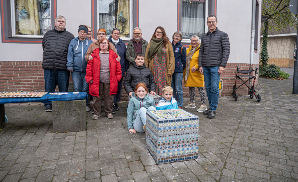 Aus Grau wird Bunt: Drei weitere Basaltquader in der Innenstadt wurden wurden jetzt in farbenfrohe Kunstwerke verwandelt. Das Foto zeigt Projektteilnehmende und Unterstützer bei der offiziellen Übergabe.