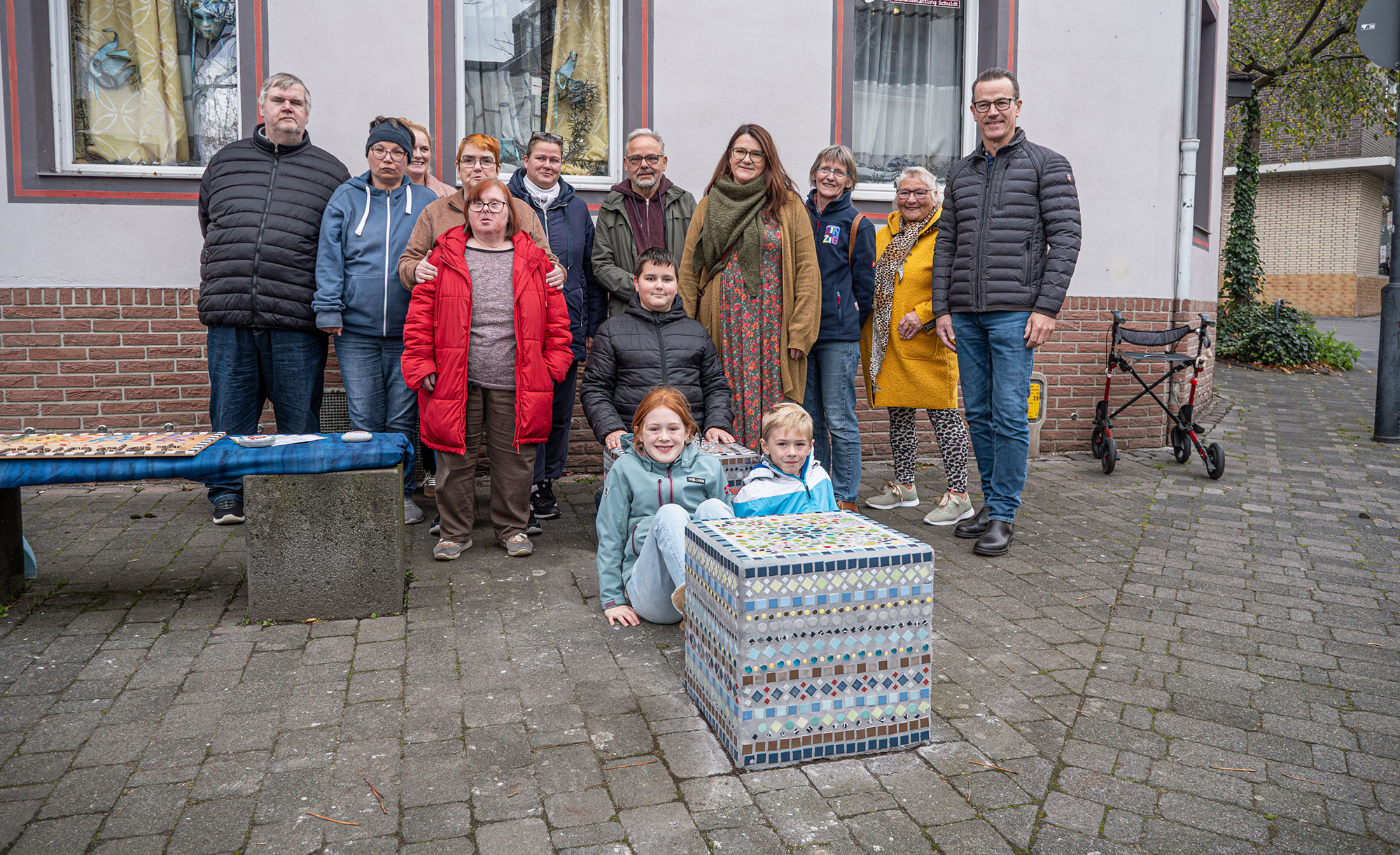 Aus Grau wird Bunt: Drei weitere Basaltquader in der Innenstadt wurden wurden jetzt in farbenfrohe Kunstwerke verwandelt. Das Foto zeigt Projektteilnehmende und Unterstützer bei der offiziellen Übergabe.